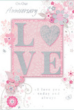 An exquisitely detailed anniversary card is depicted, styled with the same care and sensitivity a Dartford florist might bring to an elegant, long-stemmed bouquet. At the centre, the word LOVE is rendered in large, raised letters, each stroked with soft, glittering texture that catches the light in shades of blush pink, pearlescent white, and subtle silver. The glitter creates a gentle sparkle, not harsh but refined, reminiscent of morning light glancing off dewdrops on petals in a garden near Dartford's Central Park. Behind and around this central word lies a smooth, blush-pink background that gradually fades into softer tones, giving the impression of a gentle glow radiating outward. Flowing from the edges of the card, clusters of stylised blossoms, slender leaves, and curving vines drift toward the centre, their lines as graceful and deliberate as the placement of each stem in a romantic anniversary arrangement ordered for delivery across Dartford. The flowers are drawn with delicate outlines and shaded with muted blush, ivory, and silvery grey, creating a calm, almost watercolor softness. Tiny flourishes-petals, curls, and small, butterfly-like shapes-add a sense of movement and lightness, as though the design is quietly breathing. Interwoven with the florals, elegant script phrases offer anniversary wishes and declarations of lasting love, the lettering fine yet warmly expressive. The entire composition feels serene and heartfelt, like a private moment shared between partners in a familiar Dartford home. It captures that mix of gratitude and quiet joy that comes with another year together, evoking not only the beauty of flowers but also the enduring fragrance of shared memories.